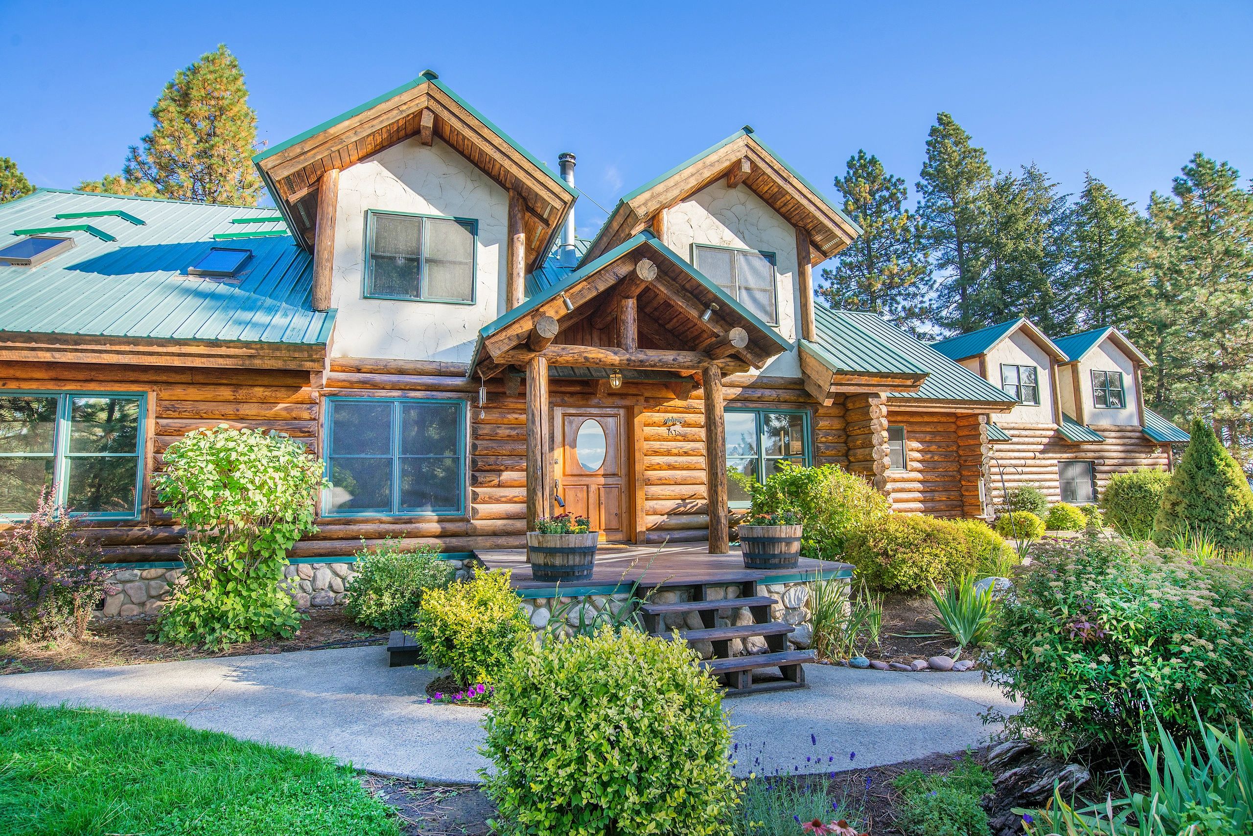 Modern log cabin with turquoise roof, North Idaho